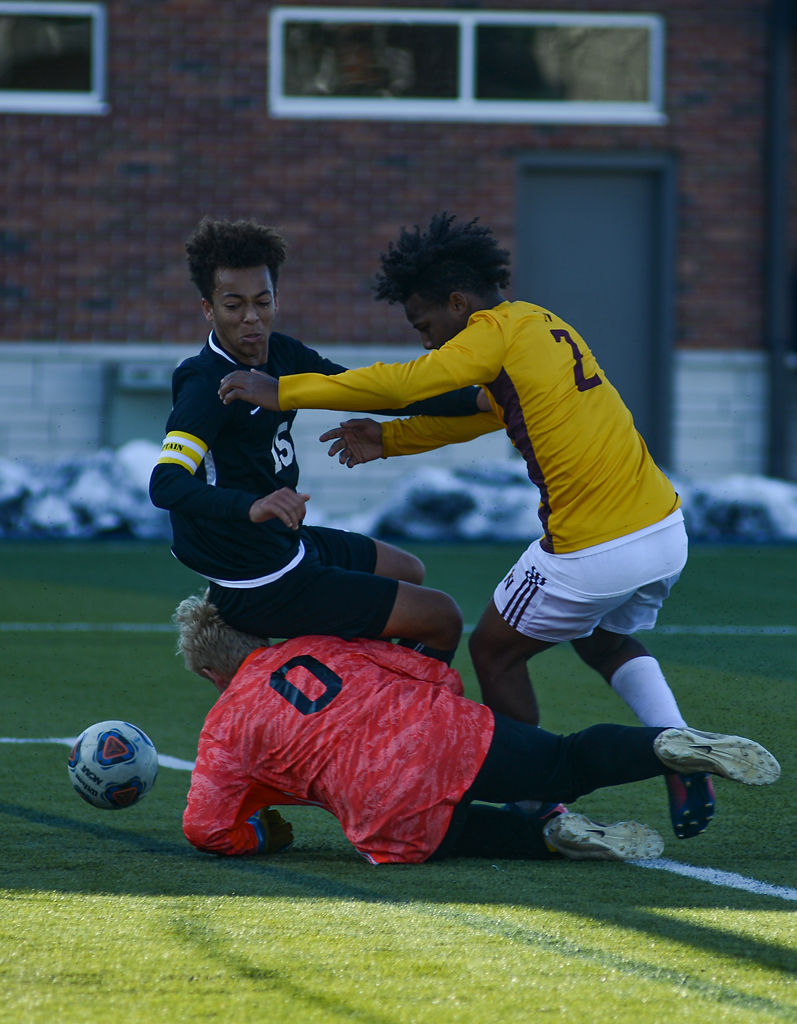 Nathan Forck (15) of Tolton Catholic High School falls under the challenge of Erik Lorenz (GK) and Fred Davis (2)